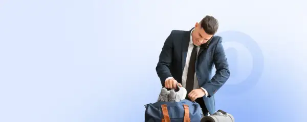 Biznesmen pakuje buty do torby sportowej, zastanawiając się, co ile godzin można korzystać z Multisport Plus.